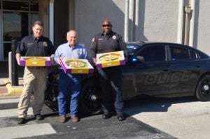 Port Arthur Police Lt. Steve Brinson, left, Rao’s Bakery owner Jake Tortorice Jr. and Officer Rickey Antoine show some of the king cake that will be given to good drivers in Port Arthur. Tortorice approached the police department several weeks ago with the idea of giving the cakes and coupons for free cookies. Mary Meaux/The News