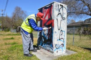 Jeff Coley, member of the Concerned Citizens of Griffing Park, removes graffiti from an AT&T box. Mary Meaux/The News 
