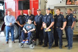 Lee Hall, far left and son Dylan Hall, seated, pose for a photo with fire fighters during a kick-off event for Port Arthur Professional Fire Fighters Association Local 397 and the Muscular Dystrophy Association’s Annual Fill the Boot Campaign at Fire Station 1 on Thursday. Mary Meaux/The News 