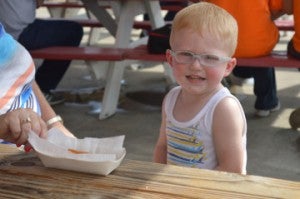 Graham Reddin, 2, takes a break to eat fries at the Nederland Heritage Festival on Friday. Mary Meaux/The News 