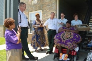 Oweda Proctor, center, shares a moment with Acadian Ambulance Service employees who have worked with her for the past two years outside her apartment on Friday. She presented a plaque, certificates of appreciation and a cake to the people she calls “Team Oweda.” Mary Meaux/The News
