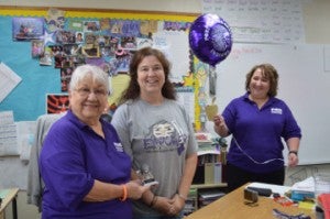 Port Neches-Groves Education Foundation members Clara Graham, left, and Peggy Harrison, right, present Groves Elementary School life skills teacher Jennifer Fecozycz with a grant on Wednesday. Mary Meaux/The News