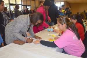 Breanna Appleberry, left, signs in with the help of volunteer Nolvia Rubens during the Seventh Annual Thanksgiving Basket Giveaway sponsored by Everlasting Changes at the Robert A. “Bob” Bowers Civic Center on Saturday. Mary Meaux/The News