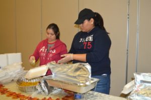 Volunteers Criselda Ordaz, left, and Samantha Cervantes dish food into trays during the Seventh Annual Thanksgiving Basket Giveaway sponsored by Everlasting Changes at the Robert A. “Bob” Bowers Civic Center on Saturday. Mary Meaux/The News 