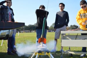 Students watch as one of their homemade rockets launches behind CO Wilson Middle School as part of their aerospace class. (Lorenzo Salinas/The News)