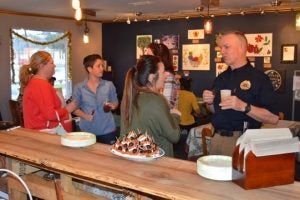 Gather workers and Chamber members stand and talk over treats at Gather: Paleo Cafe & Market’s ribbon cutting Thursday. (Lorenzo Salinas/The News)