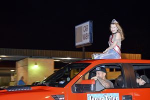 One of the festival royalty smiles and prepares to throw more candy at the crowd on Nederland Avenue. (Lorenzo Salinas/The News)